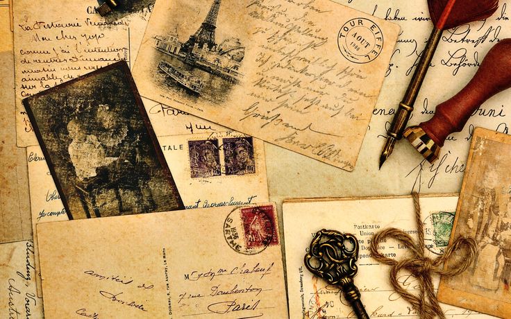 an old key is laying on top of some letters and postcards that are all over the place