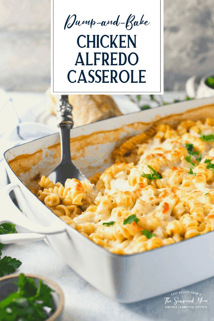 chicken alfredo casserole in a white dish with a serving spoon and parsley on the side