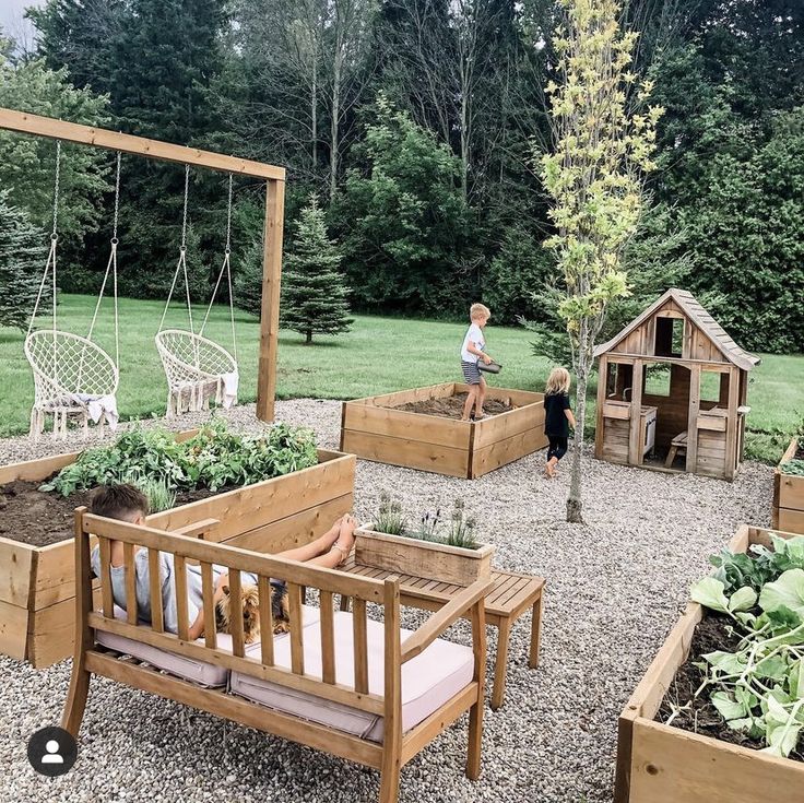 children are playing in the backyard garden with wooden benches and raised planters, while an adult looks on