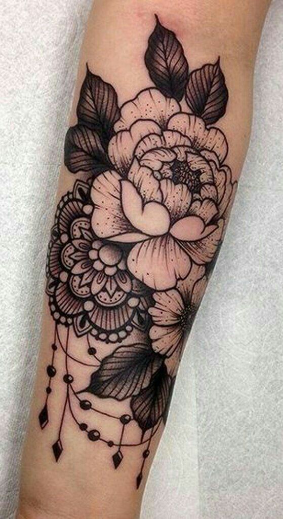 a black and white flower tattoo on the arm