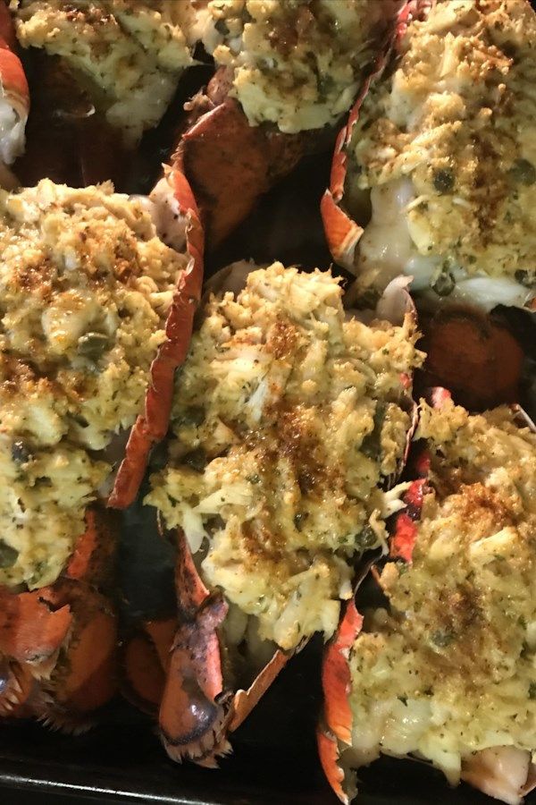 cooked lobsters with cheese and seasoning on the top are ready to be eaten