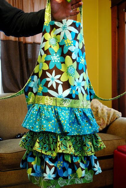 a woman holding onto a colorful dress with flowers on it