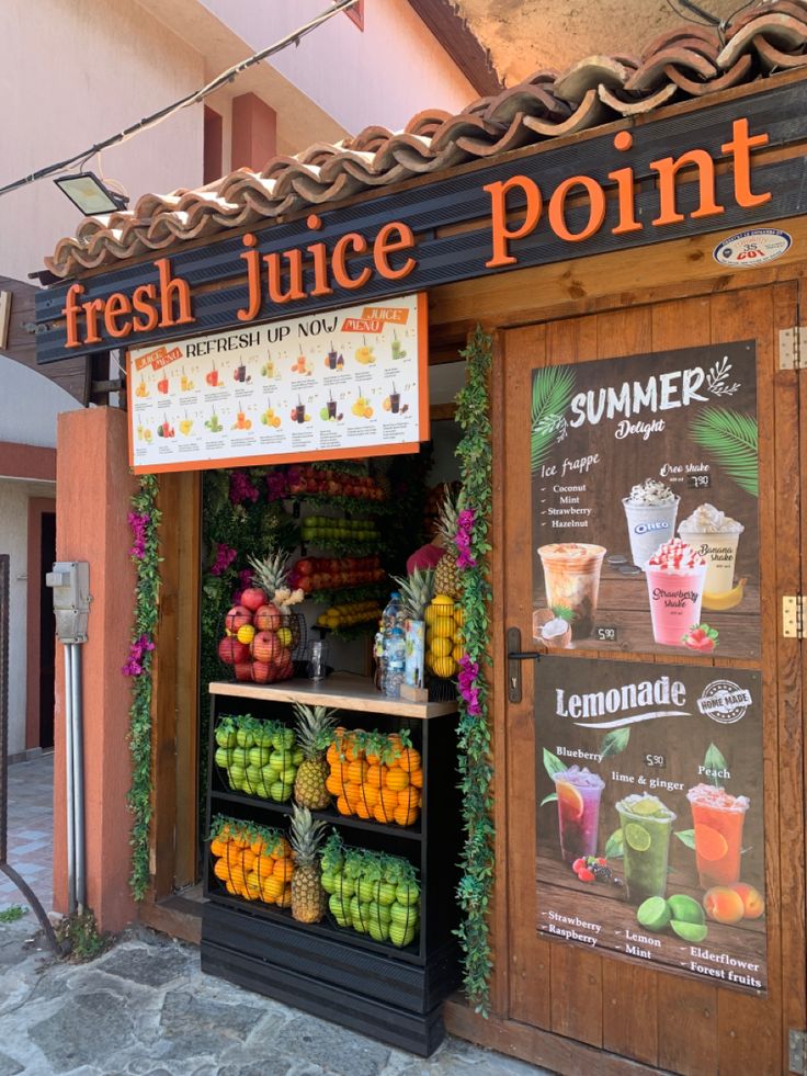 a fresh juice point with fruits and vegetables on display in front of the storefront