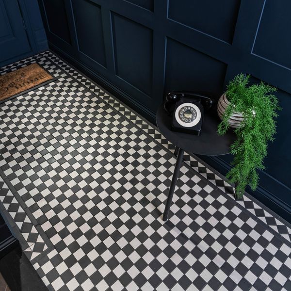 a black and white checkered floor with a phone on the table next to it