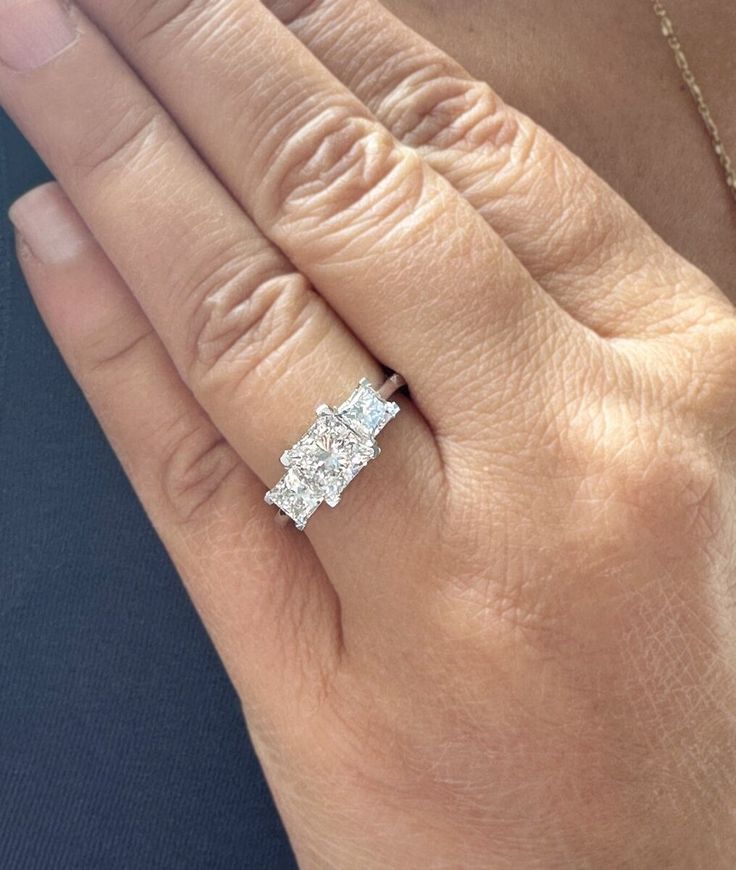 a woman's hand with a diamond ring on it