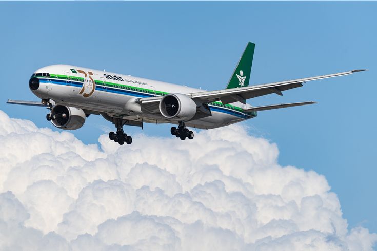 an airplane is flying in the sky above some white clouds and blue sky with green trim