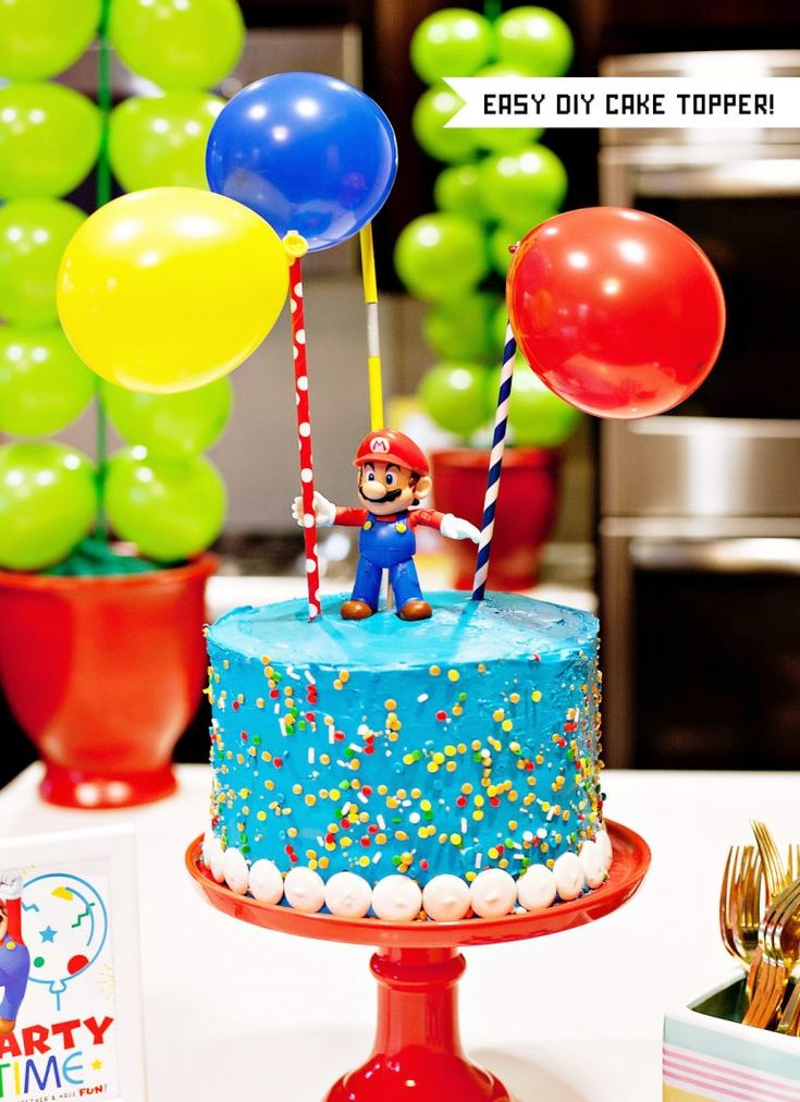 a birthday cake is decorated with balloons and candy