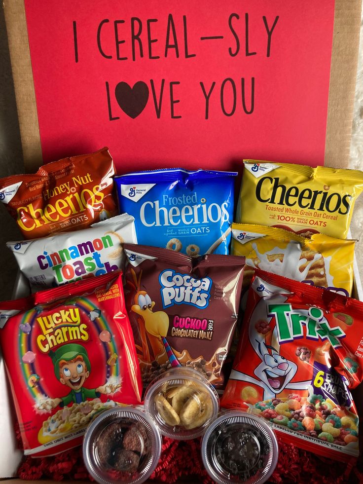 a box filled with lots of different types of snacks and candy in front of a sign that says i cereal - slay love you