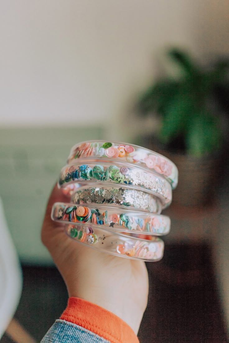 a child's hand holding several bracelets