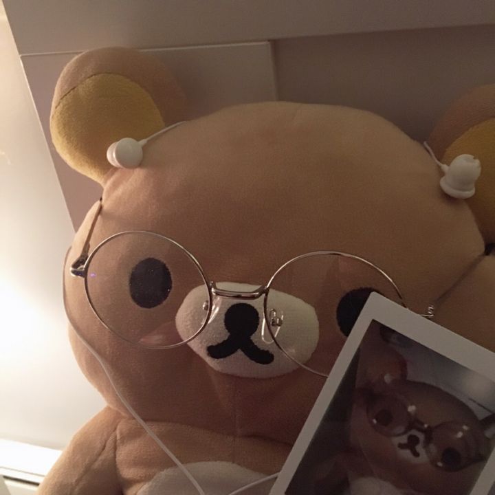 a brown teddy bear wearing glasses and holding a baby