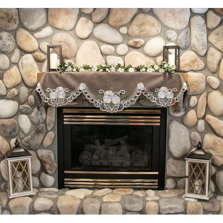 a stone fireplace with two lanterns and a mantle decorated with flowers on the mantel