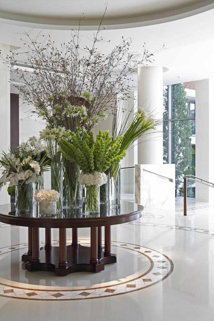 a table with vases and flowers on top of it in front of a window