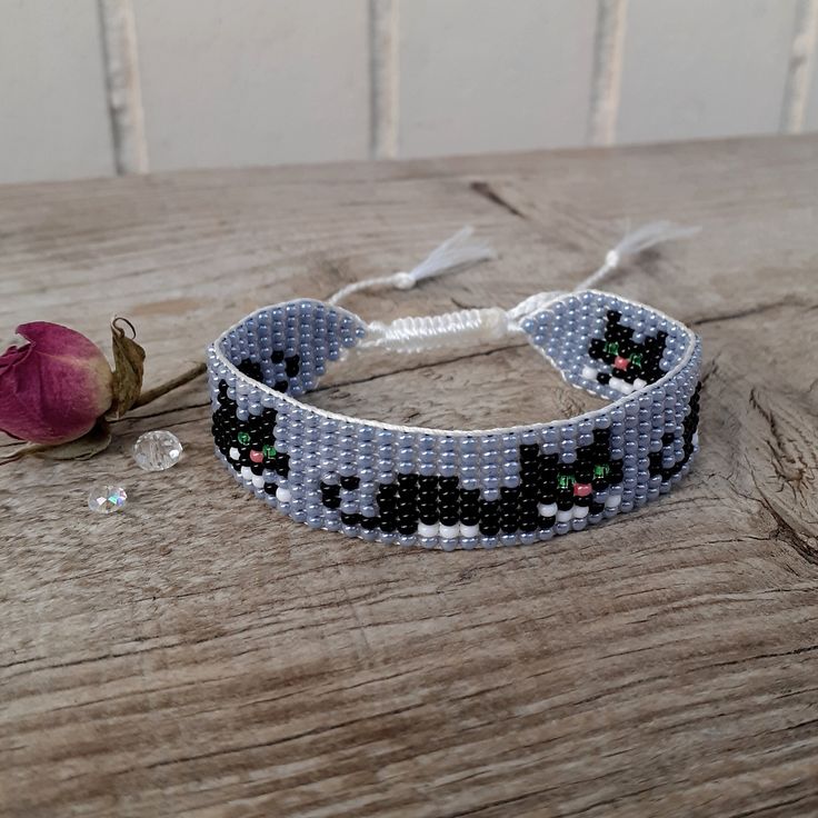 a beaded bracelet with a flower on it and a rose sitting next to it