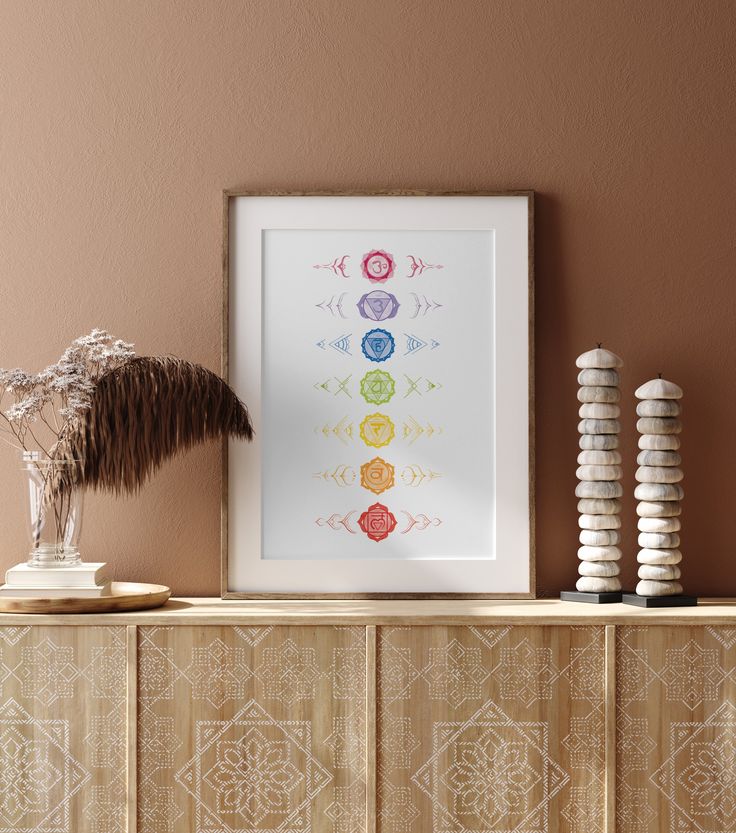 an art print with seven chakras is displayed on a shelf next to two vases