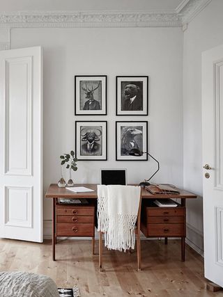 an image of a room with pictures on the wall and a desk in front of it