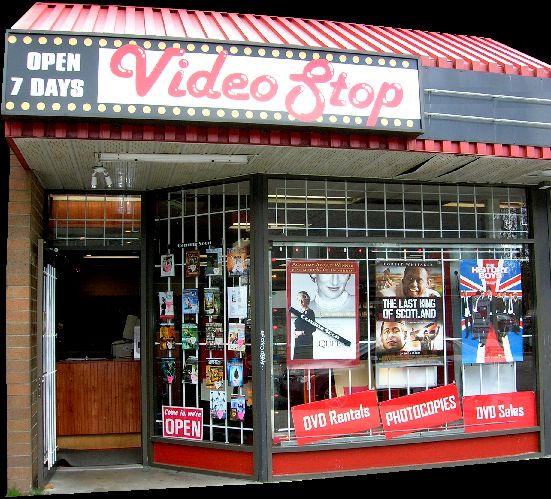 the front of a movie shop with signs on it