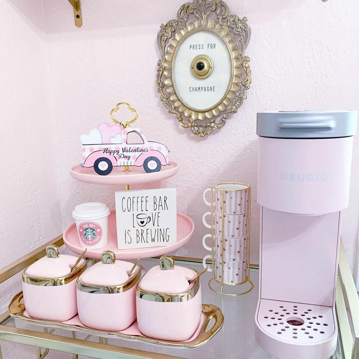 there is a pink coffee bar with cups and mugs on the tray next to it