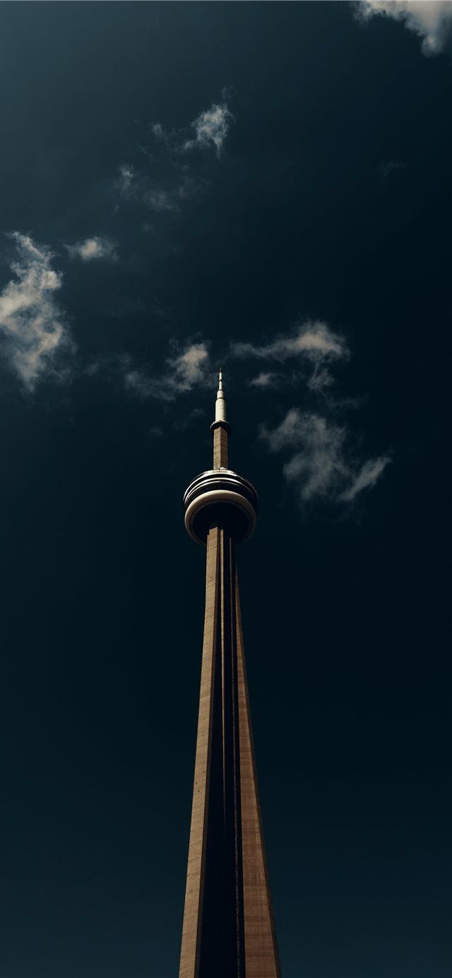 a tall tower with a clock on it's side under a cloudy blue sky