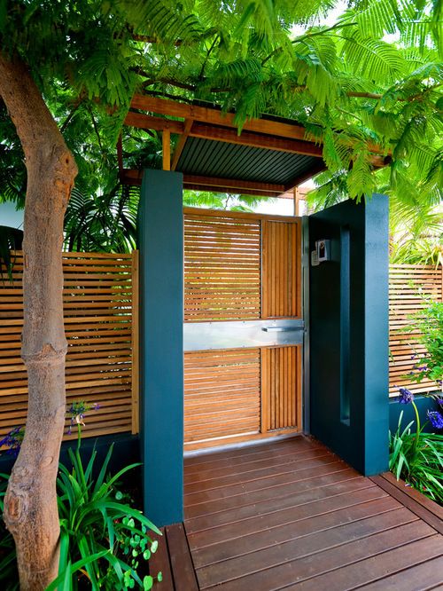 an outdoor shower is surrounded by plants and trees