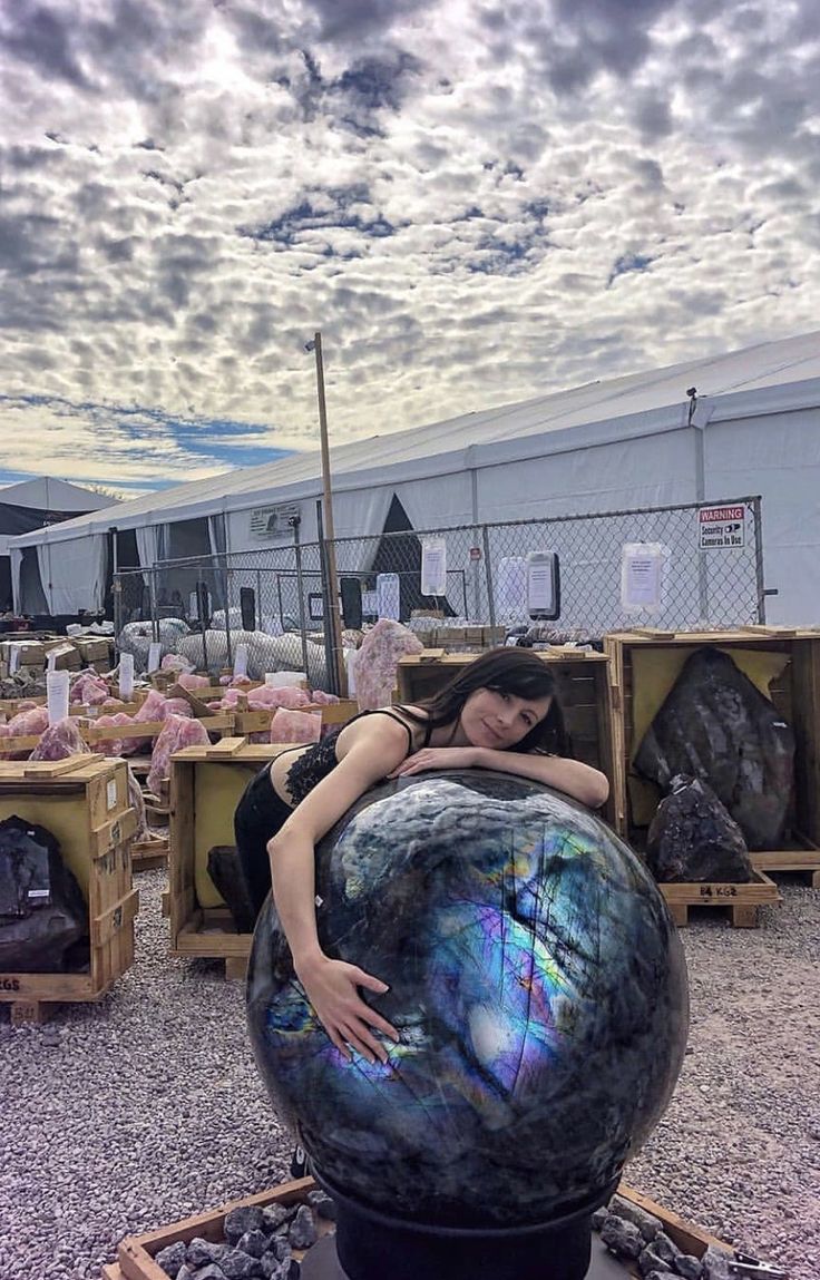 a woman sitting on top of a large ball