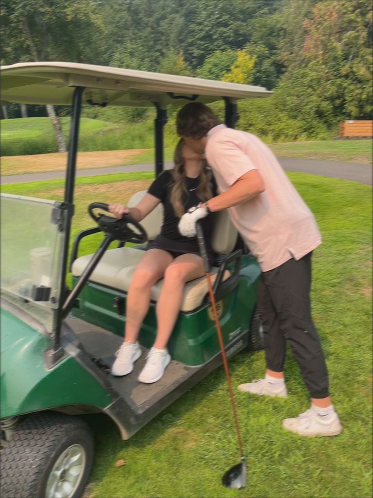 a man helping a woman ride in a golf cart