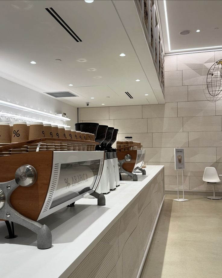 a row of coffee machines sitting on top of a counter in a room with white walls