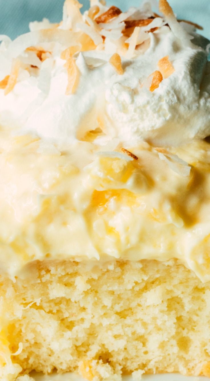 a close up of a piece of cake on a plate with whipped cream and coconut