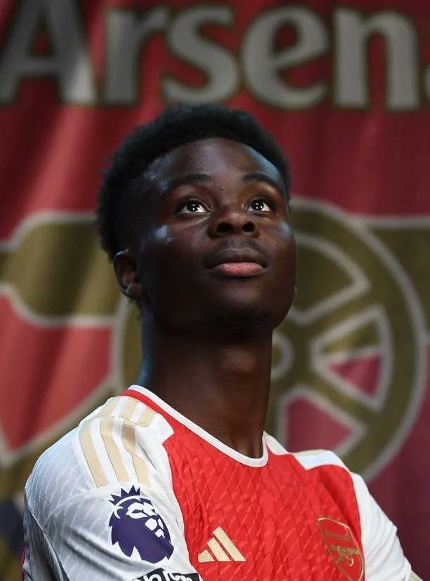 a young man standing in front of a red and white banner with the words asensia on it