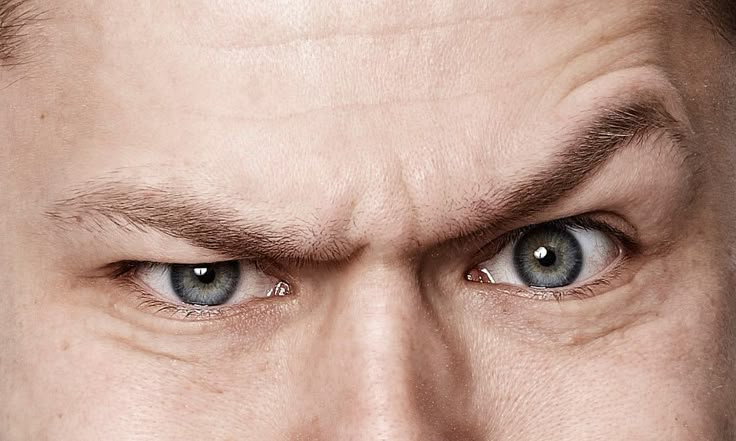 a close up of a man's face with blue eyes