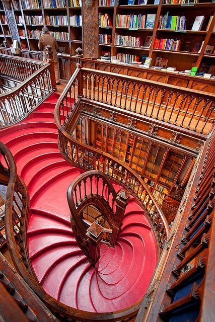 a spiral staircase in a library with bookshelves