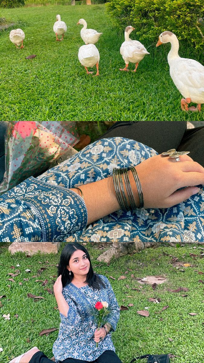 a woman sitting on the ground next to ducks