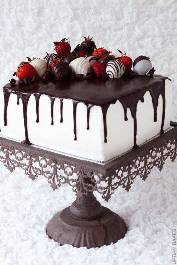 a white cake with chocolate drizzle and strawberries on top