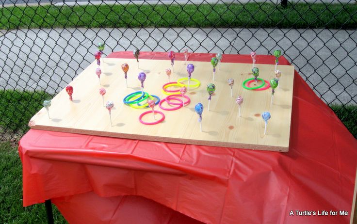 a table that has some lollipops on it and is near a chain link fence