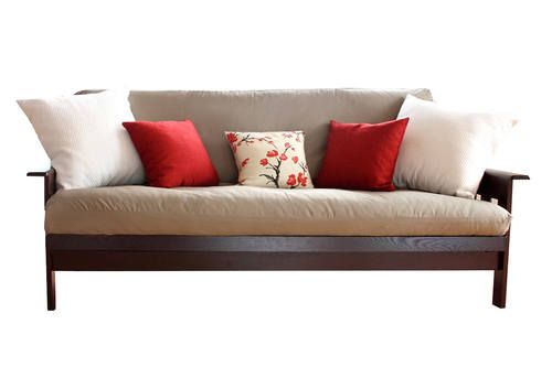 a couch with red and white pillows sitting on it's back end, in front of a white background