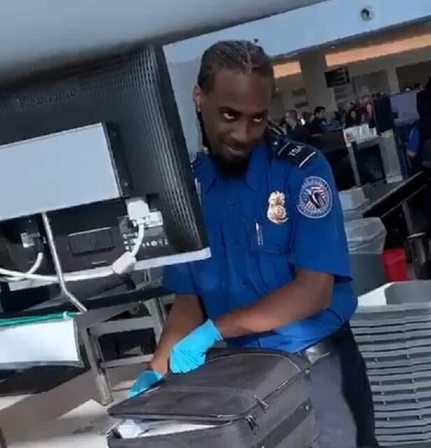 a man in blue shirt and gloves standing next to luggage