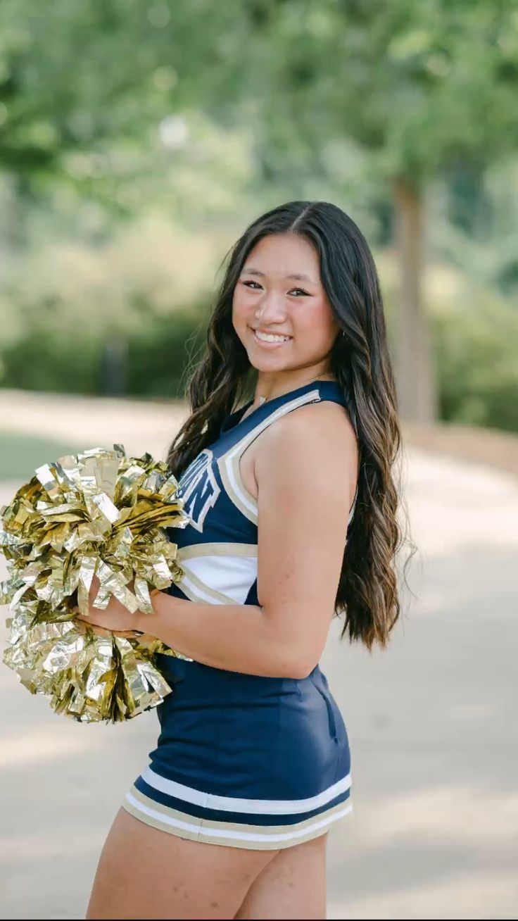 a cheerleader posing for a photo with her pom poms