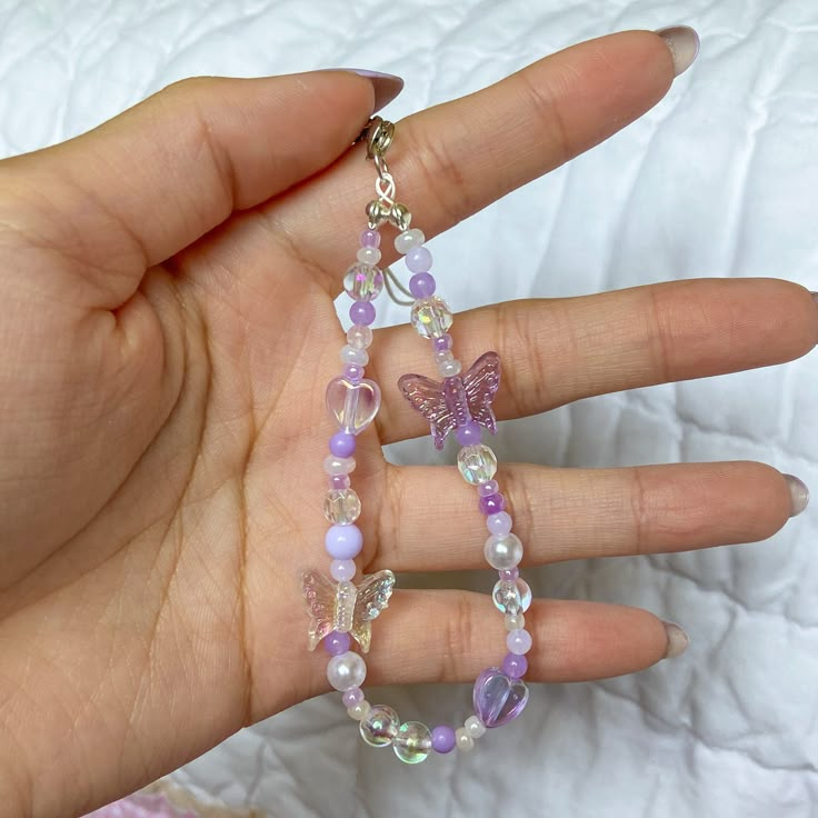 super adorable clear and purple phone keychain strap; can also be a backpack/airpod keychain if you choose the swivel clasp option! these are handmade by me with beads, and each one will be a little different (unless you request for it to look exactly like one of the ones shown in the pictures) -phone charm (including the string strap)is roughly 15cm or 17cm (may vary slightly)  -the regular length keychain from the beads themselves from jump ring to the bottom of charm is roughly 9cm, the extra Purple Phone Charm, Airpod Keychain, Keychain Y2k, Kpop Keychain, Phone Keychain, Backpack Keychain, Y2k Accessories, Bead Charms Diy, Diy Bracelets Patterns