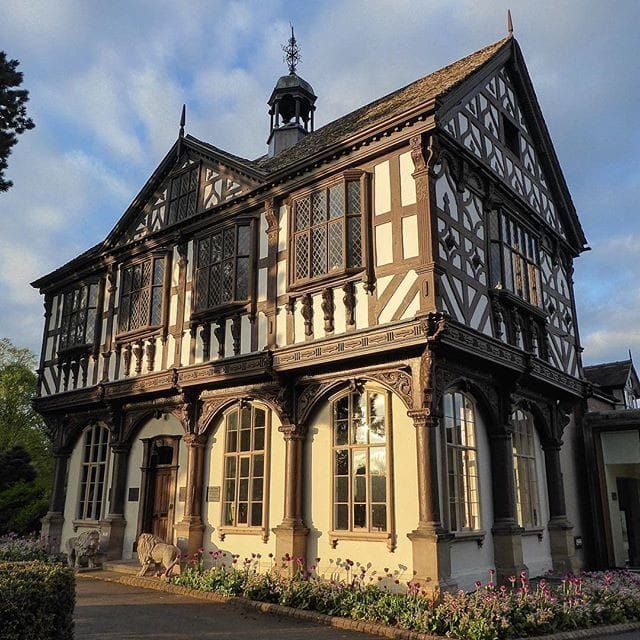 an old building with many windows and flowers in front