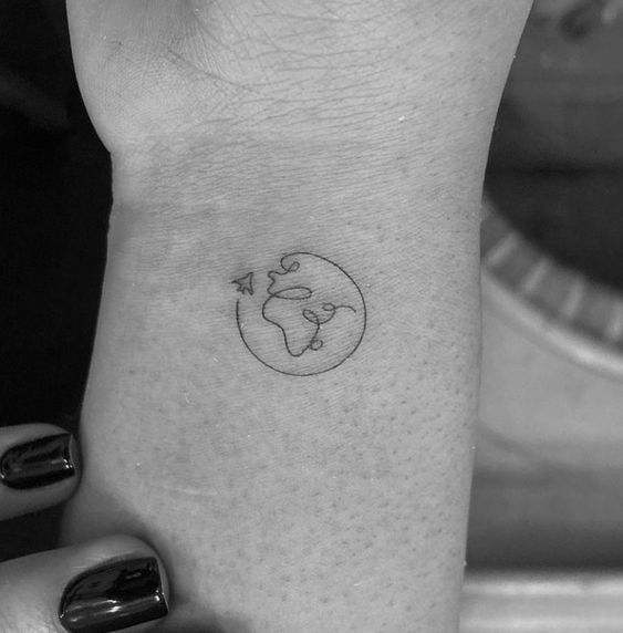 a woman's hand with a small tattoo on the left side of her wrist