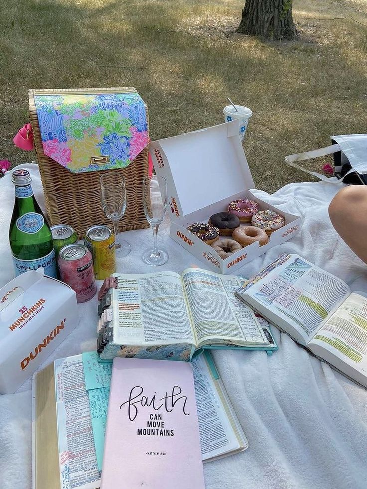 an open book sitting on top of a table next to a basket filled with donuts