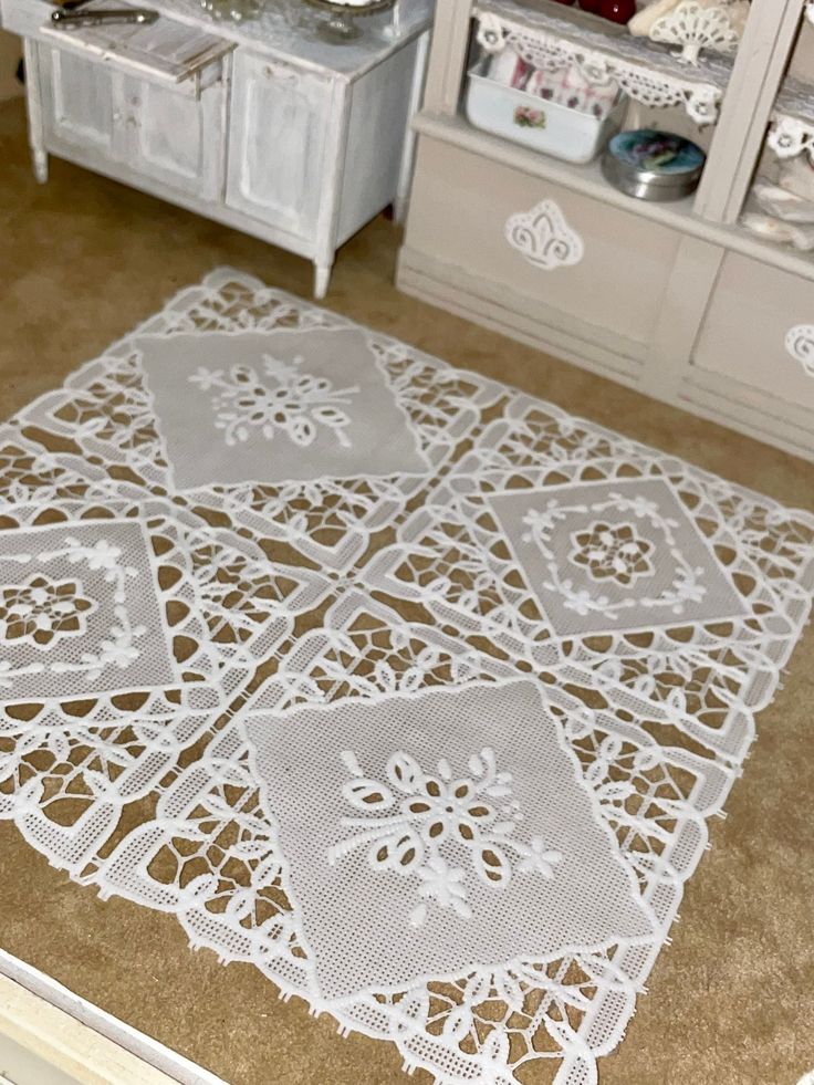 a white table with doily on top of it in a room filled with furniture