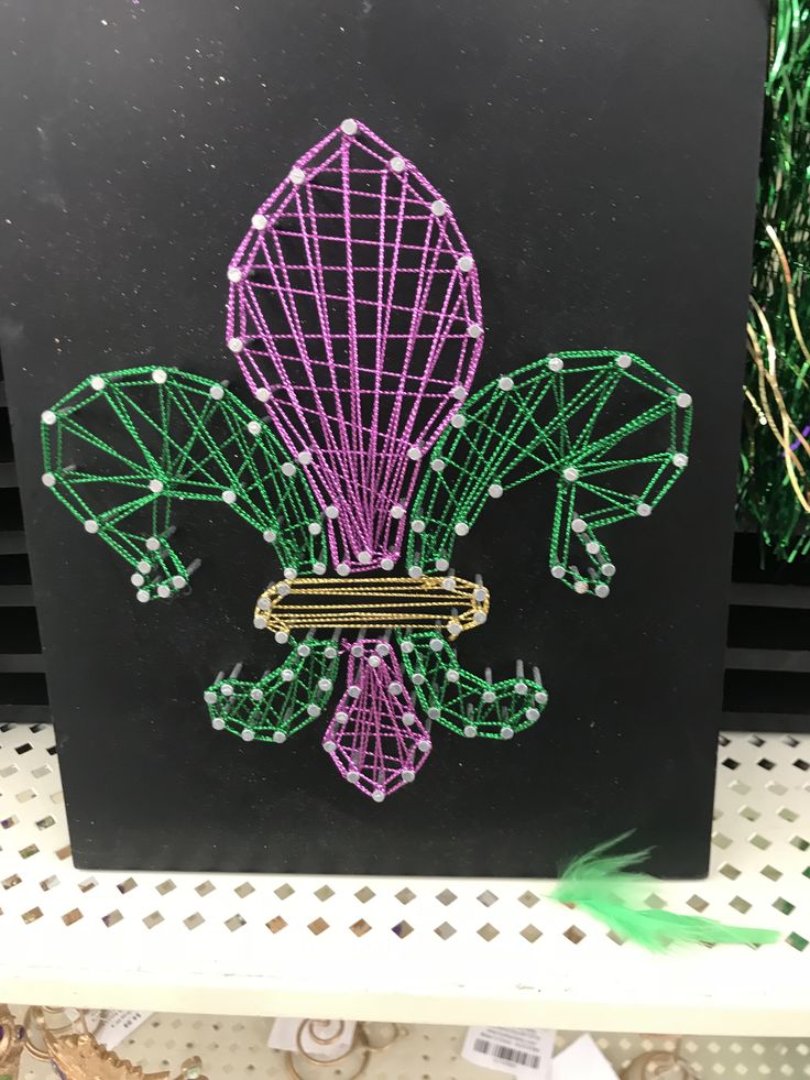 a black box with purple and green string work on it