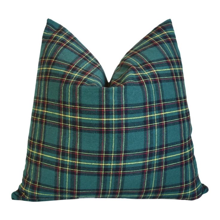 a green plaid pillow on a white background