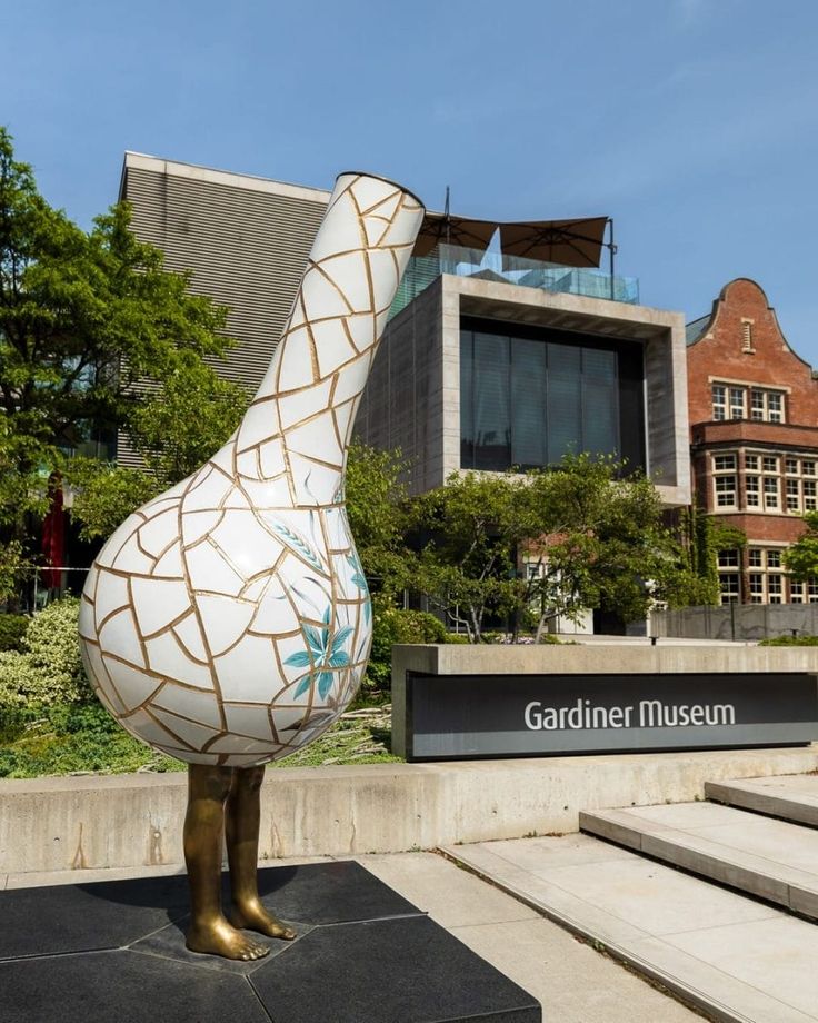 a large white duck statue sitting in front of a building