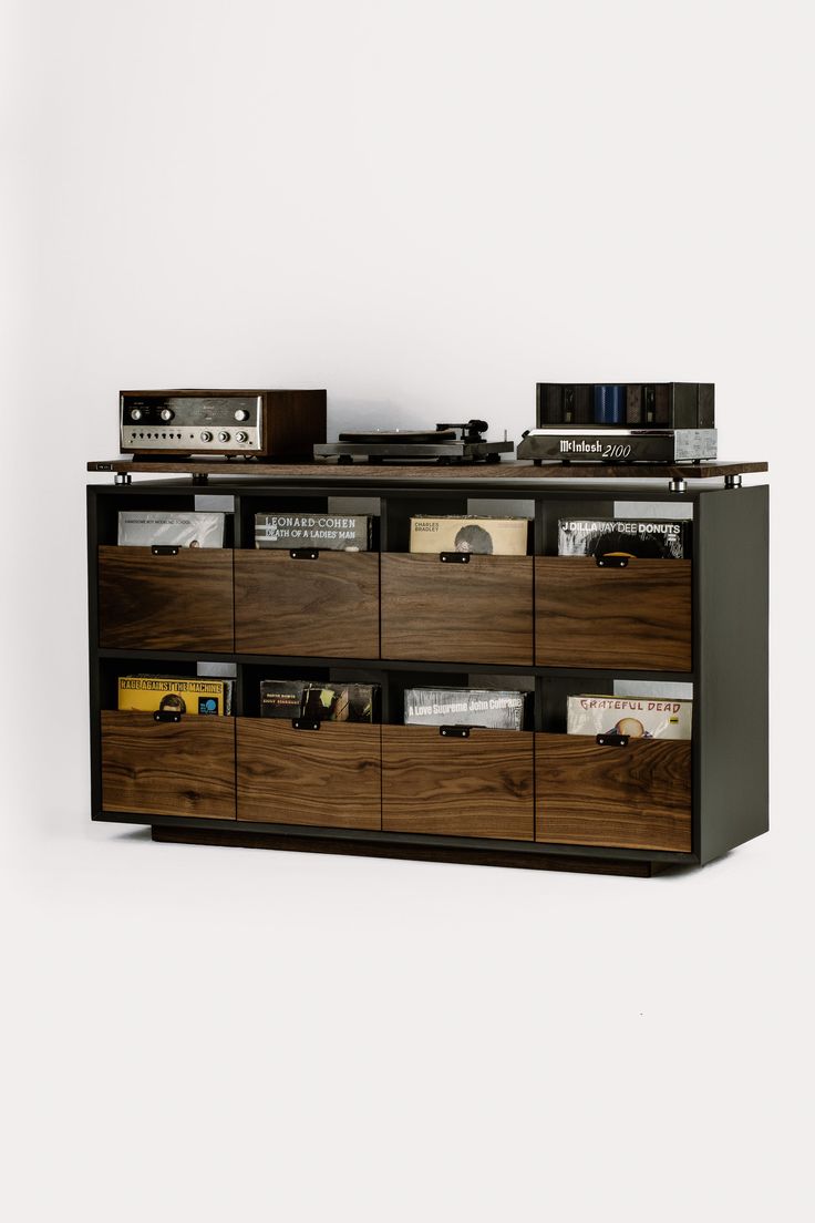 the sideboard is made out of wood and has many compartments for cd's