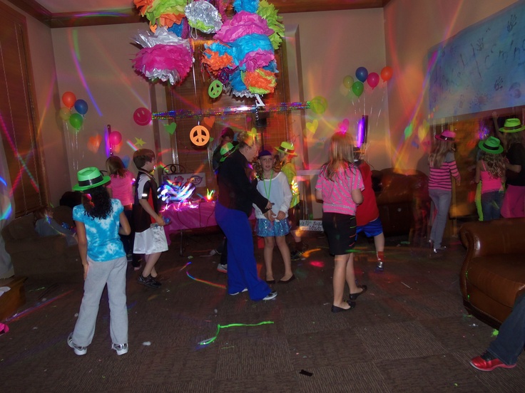 a group of people standing around each other in a room with balloons and streamers