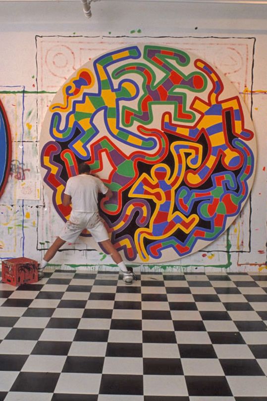 a man standing in front of a painting on the wall