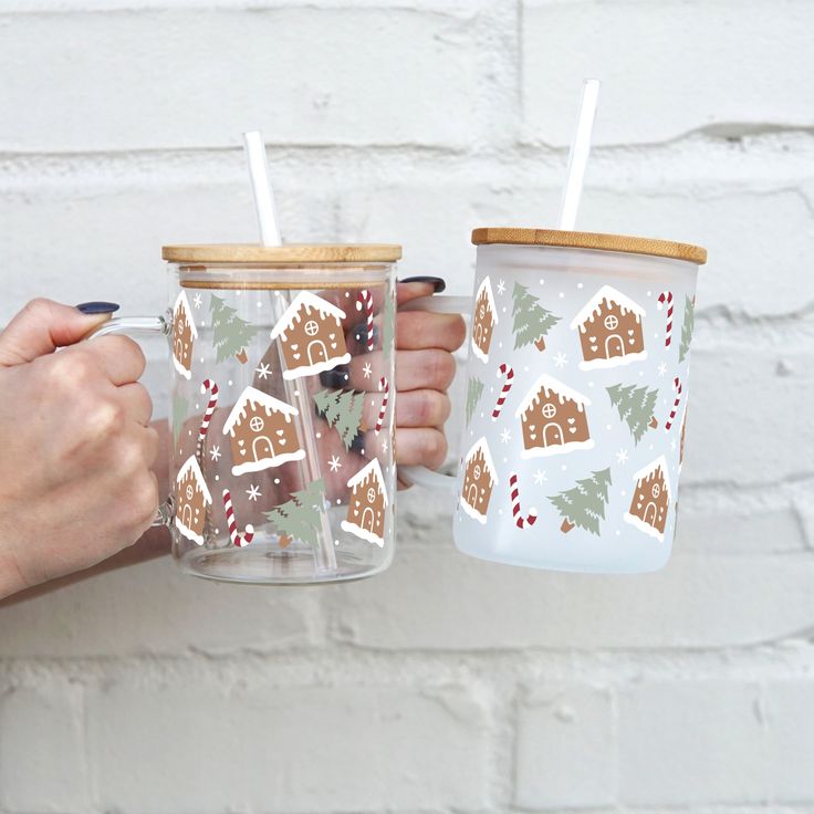 two people holding cups with christmas decorations on them