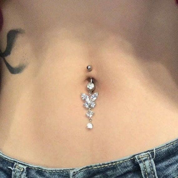 a woman's stomach with a diamond belly ring attached to the back of her body