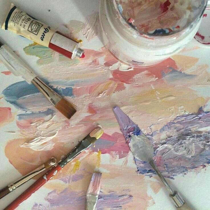 some paint brushes and paints sitting on top of a table